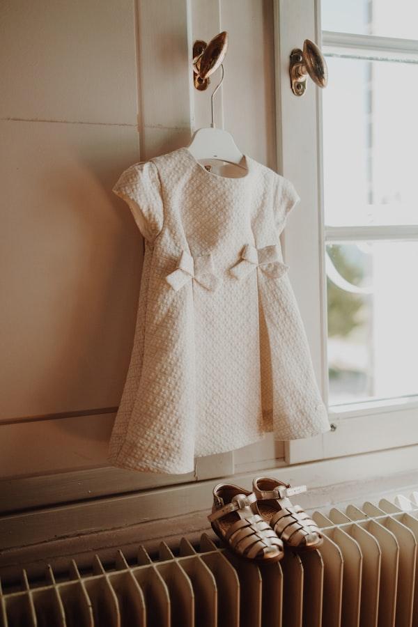 Vestido claro de renda pendurado em um cabide.
